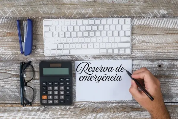 Onde investir sua reserva de emergência: 5 ideias seguras para iniciantes 2 calculadora e caderno simbolizando planejamento financeiro da reserva.